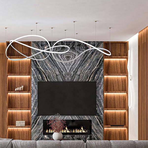 A white abstract chandelier installed in front of a textured feature wall with built-in shelving and a fireplace.